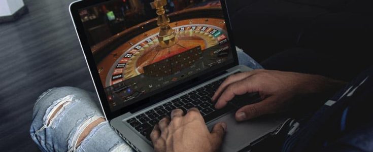 Meneer is aan het online gokken via de laptop